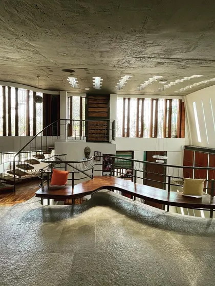 Buildings do talk, and this one speaks of light and form. I designed this space with undulating floors and walls pierced by slits of light, creating a conversation between the structure and the sun. The built-in seating flows organically from the architecture itself.