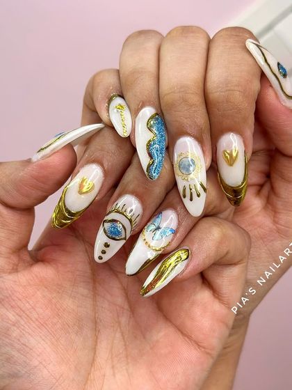 An evil eye-inspired set with a mix of white, blue, and gold chrome. This design is full of intricate details and protective symbols.