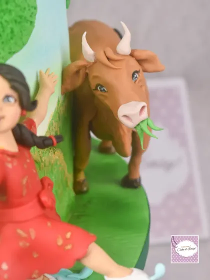 A detail from the 'Dharma' side of the storytelling cake, featuring a happy cow grazing in a lush green field. Capturing a content expression on an animal figurine adds so much life to the scene.