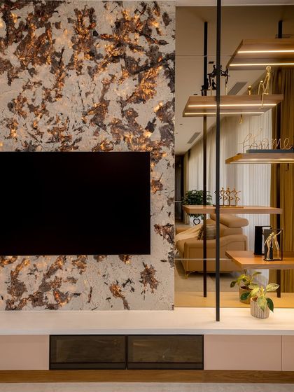 This stunning TV backdrop is crafted using backlit quartzite, a natural stone known for its durability and unique veining. When backlit, it creates a mesmerizing effect, adding depth and warmth to the living room.
