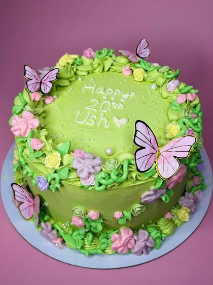 When a client asks for an enchanted garden, they get an enchanted garden. This cake features a soft green base with a cascade of buttercream flowers and delicate wafer paper butterflies.