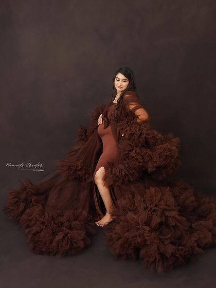 A powerful pose in a dramatic brown gown. The flowing fabric and confident stance create a striking and artistic solo maternity portrait.