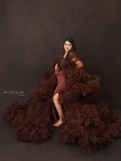 A powerful pose in a dramatic brown gown. The flowing fabric and confident stance create a striking and artistic solo maternity portrait.