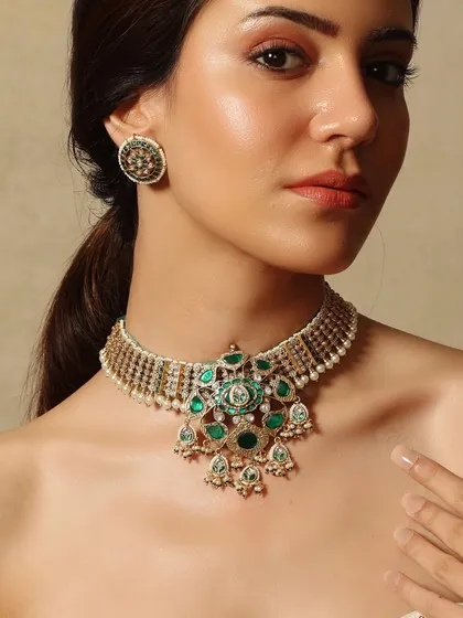 This Emrosia choker features a central floral pendant crafted with deep green emeralds and polki, a piece that is both delicate and striking.