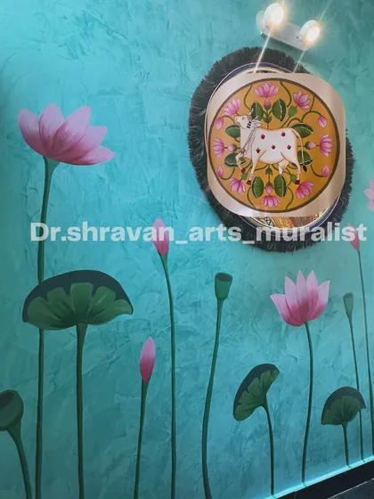 Here, I combined a textured wall finish with painted elements to create a unique look. The lotus stems appear to grow up the wall, leading to a central, framed Pichwai painting that acts as the focal point.