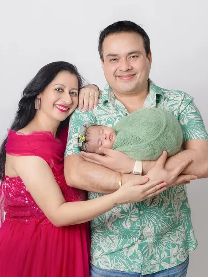 A proud mother and father with their precious newborn. The way they hold their baby shows so much love and care.