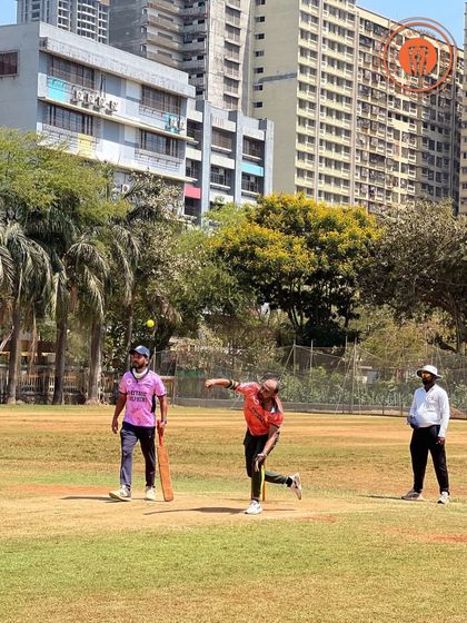 A bowler releases the ball during a men's PPL match, with players in colorful jerseys in the background.