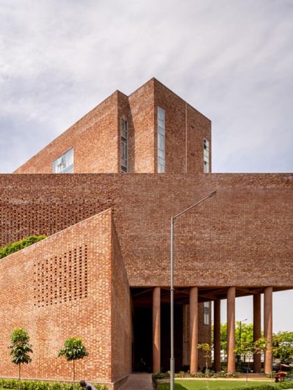 The building's form is a composition of interlocked triangular and cuboid volumes, creating a complex and visually engaging piece of architecture.