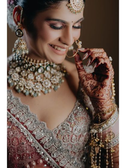 A joyful close-up of Vasudha, capturing her laughter and the intricate details of her henna and jewelry. This image is full of life and authentic emotion.