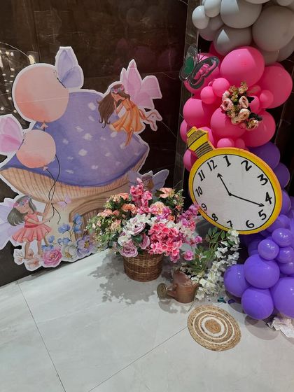 Another shot of the fairy and mushroom cutouts, paired with a prop clock and balloon clusters.