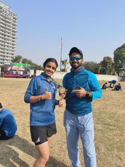 Two runners with their medals after the race, celebrating a successful finish together.