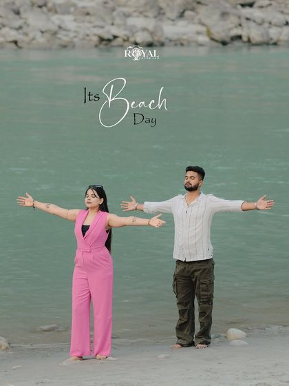 A playful "beach day" photo of an expecting couple with their arms outstretched, embracing the open space by the Ganga. This captures a feeling of freedom and joy.