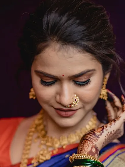 A close-up of this bride's engagement makeup. I focused on creating a flawless, glowing base with soft smokey eyes and a classic Maharashtrian nath to enhance her natural beauty.