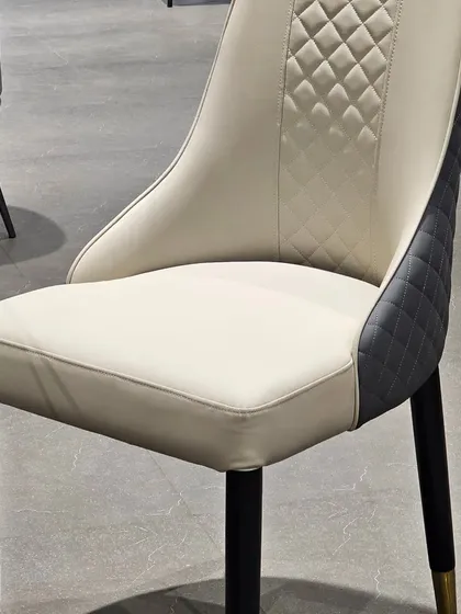 This premium dining chair features a dual-tone design with diamond-quilted stitching on the back. The combination of smooth and textured leatherette adds a layer of sophistication.
