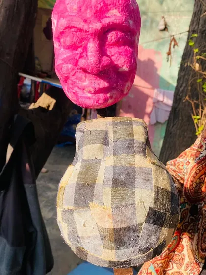 This is a puppet head after the papier-mâché has been applied and dried, ready for the next stage. You can see the basic facial features have been formed, creating a blank canvas for painting.