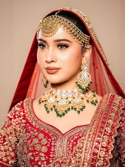 A classic bridal pose looking away from the camera. This angle highlights the perfect blending of her foundation, the sharp contour of her cheekbones, and the intricate details of her bridal jewelry.