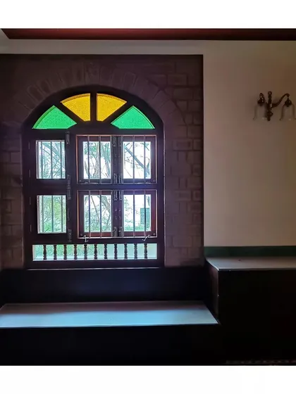 An arched window with colored glass panes creates a beautiful focal point in this room with exposed brick walls.