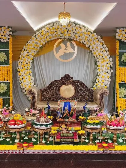 A baby shower setup with a yellow and green checkered backdrop and a floral arch. The plate decoration is symmetrical and visually appealing.