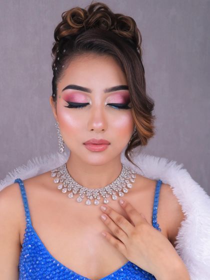 A stunning party look with a creative pink and blue eye, messy bun, and diamond jewelry. This shows the versatility of looks you can learn to create.