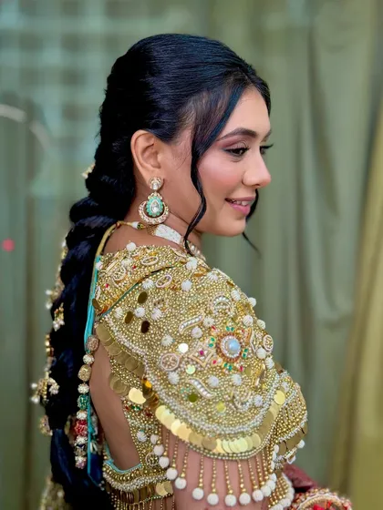 A side profile showing the intricate hairstyle and the shimmering makeup.