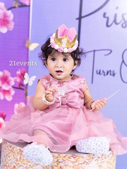 The birthday princess herself, enjoying her cake in front of the beautiful decor.