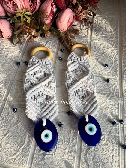 Another beautifully styled shot of the macrame evil eye hangings. The white knots contrast perfectly with the deep blue of the charm.