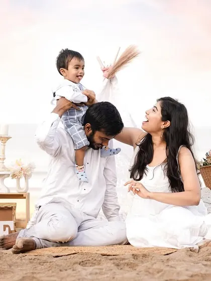 Celebrating a first birthday with a beautiful beach photoshoot. The soft sunset light, coordinated white outfits, and rustic props create a magical setting for this milestone.