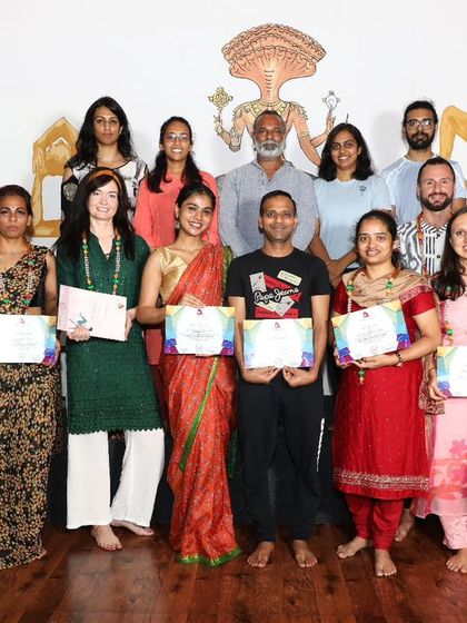 A group of students celebrates the completion of their 10-day intensive workshop, a program designed to explore various yoga forms.