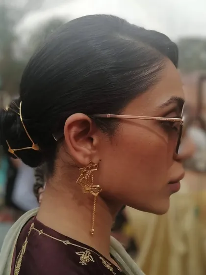 A sleek and modern low bun, elevated with a stunning gold hair accessory. This minimalist yet chic hairstyle is perfect for a wedding guest who wants a sophisticated look.