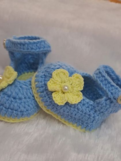These sky blue Mary Jane booties are adorned with a cheerful yellow flower, creating a beautiful color contrast.