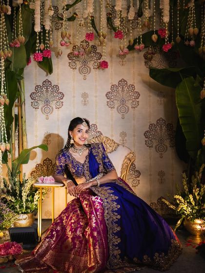 Our bride Sindhu, looking radiant during her pellikuthuru ceremony. The decor, inspired by peacocks, featured a custom backdrop with traditional patterns and lush floral arrangements to complement her stunning attire.