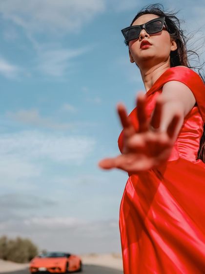 A creative and playful shot with a focus on the bride. This image has a strong fashion-forward feel, highlighting her confidence and style against the bright blue Dubai sky.
