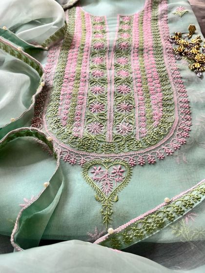 A close-up of the heart-shaped motif at the base of the neckline, a unique design element.