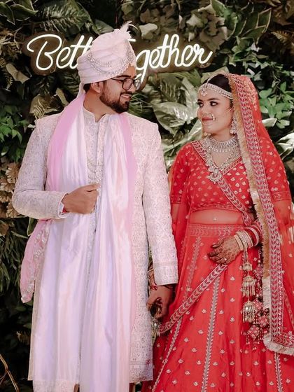 A lovely wedding day portrait against a "Better Together" neon sign. The soft lighting and the couple's loving gaze make this a sweet and modern wedding photo.