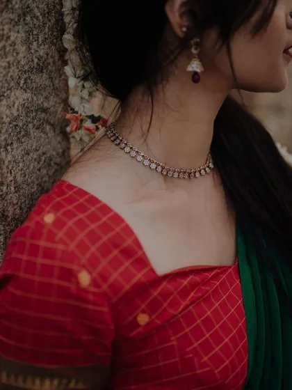 A detail shot focusing on the neckline, jewelry, and fabric of a traditional outfit. This type of shot is perfect for highlighting the craftsmanship of designers and jewelers.