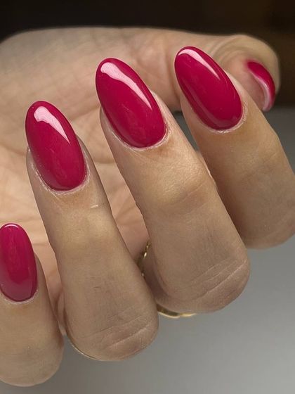 A vibrant, glossy magenta manicure on long, oval nails. This bold pink-purple shade is full of personality and style.
