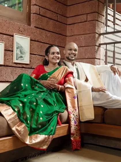 A relaxed and happy portrait of the couple lounging together, perfectly at ease in their beautiful home and traditional outfits.