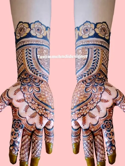 This design features a prominent arch pattern on the back of the hand, filled with delicate details and topped with a floral cuff. The use of blue and black henna adds a modern twist.