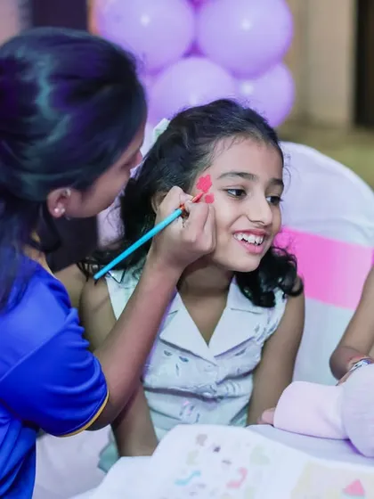 A happy girl getting her face painted. Face painting is a classic party activity that transforms kids into their favorite characters or animals.