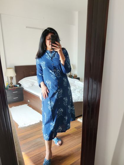 The full view of the indigo cotton dress. Its A-line cut and classic print make it a versatile piece that can be dressed up or down depending on the occasion.