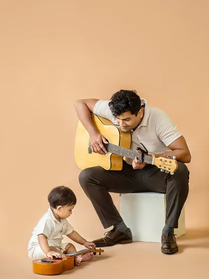 The final shot from the jam session. A candid moment where the little one is fascinated by the small guitar, creating a natural and adorable scene.