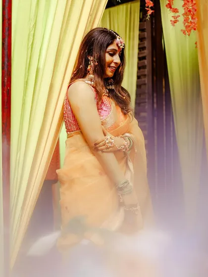 A beautiful, soft-focus shot of the bride during her Haldi, with a dreamy fog effect adding to the magical atmosphere.