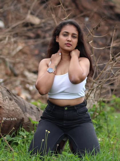 A powerful and direct portrait in an outdoor, rustic setting. The focus is on the subject's confident gaze.