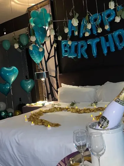 A chic and modern birthday surprise using a unique teal color scheme, complete with a champagne bucket for a touch of luxury.