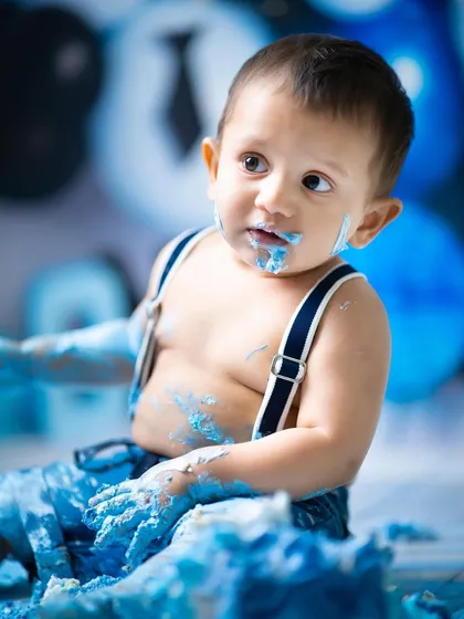 A close-up of the birthday boy, covered in blue frosting and happiness. These are the wonderfully chaotic moments that make for the best memories.