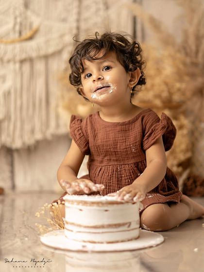 This little girl is having so much fun with her rustic-themed cake smash. Her expression is priceless.