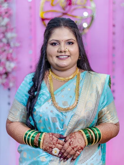 A happy, smiling close-up of the bride-to-be. This shot highlights the flawless makeup application, from the smooth base to the defined eyes and the traditional bindi, all coming together for a perfect engagement look.