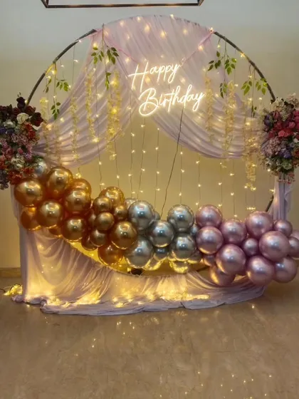 Another angle of the round birthday backdrop, highlighting the floral arrangements and the soft glow of the lights.