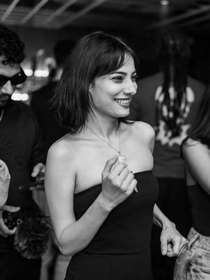 A beautiful black and white candid of a guest smiling and dancing.