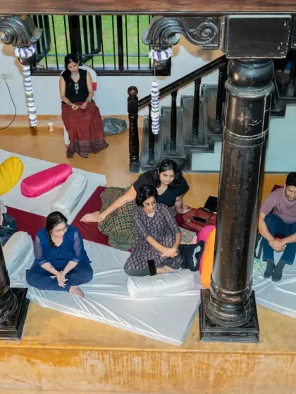 An overhead view of our community relaxing during a session at Kavi Mane Utsav. The floor seating with mattresses and pillows creates a comfortable, informal atmosphere for sharing and listening.